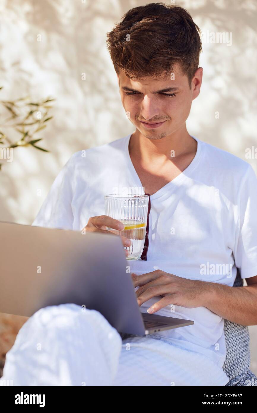 A person holding a glass of water in front of a window · Free Stock Photo