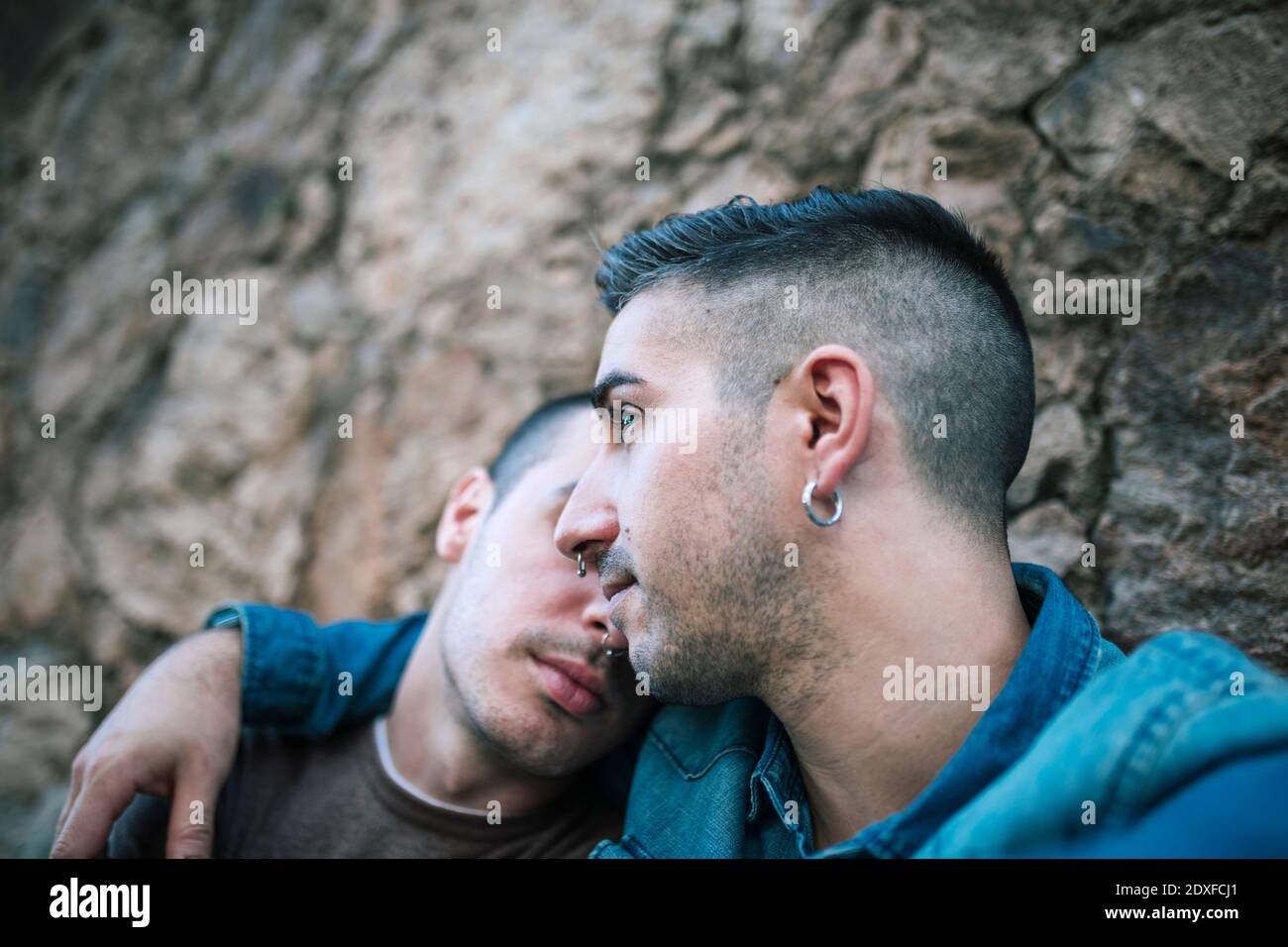 Thoughtful man looking away while boyfriend leaning on his shoulder Stock Photo