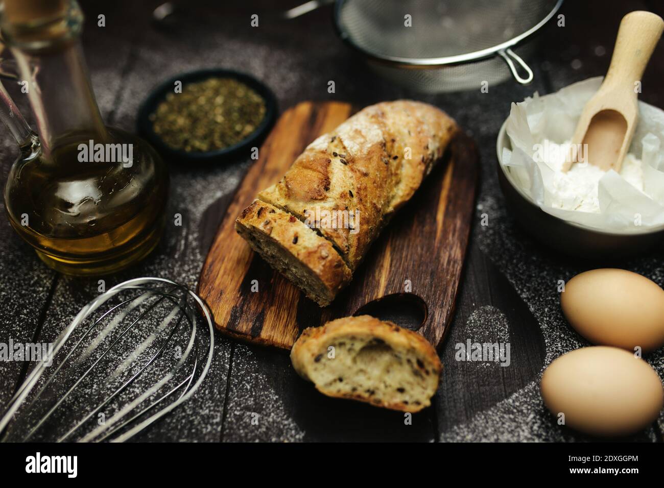 Fresh baked bread and baking ingredients on a table Stock Photo