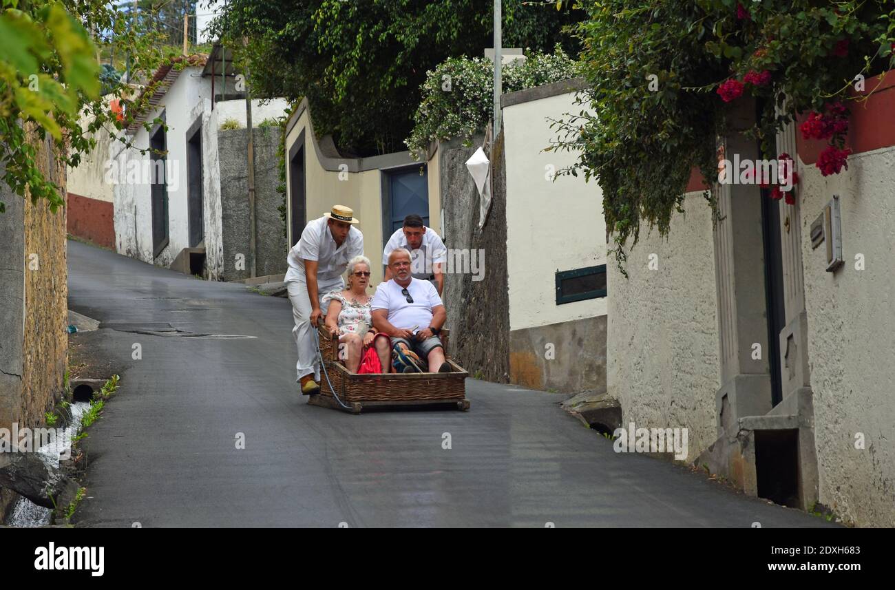 Funchal Madeira older couple having downhill basket ride Stock Photo