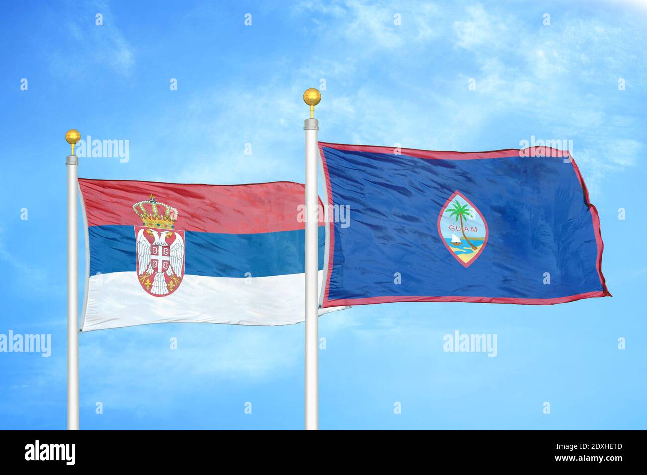 Serbia and Guam two flags on flagpoles and blue sky Stock Photo