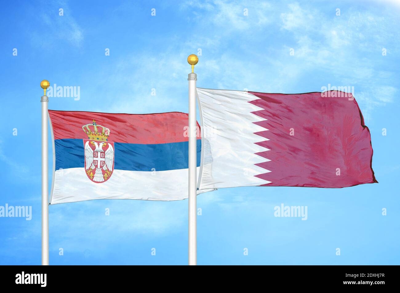 Serbia and Qatar two flags on flagpoles and blue sky Stock Photo
