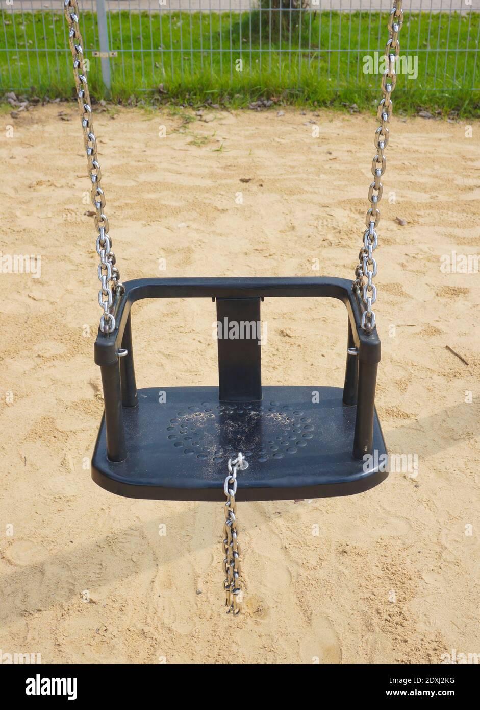 Swing set seat hanging on metal chains at a playground Stock Photo Alamy