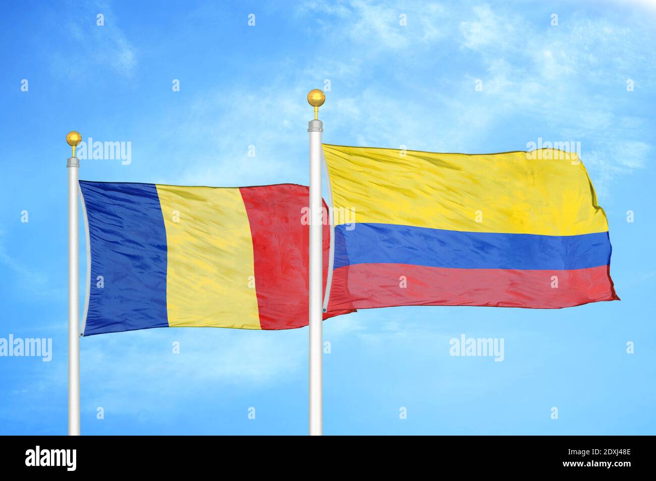 Romania and Colombia two flags on flagpoles and blue sky Stock Photo