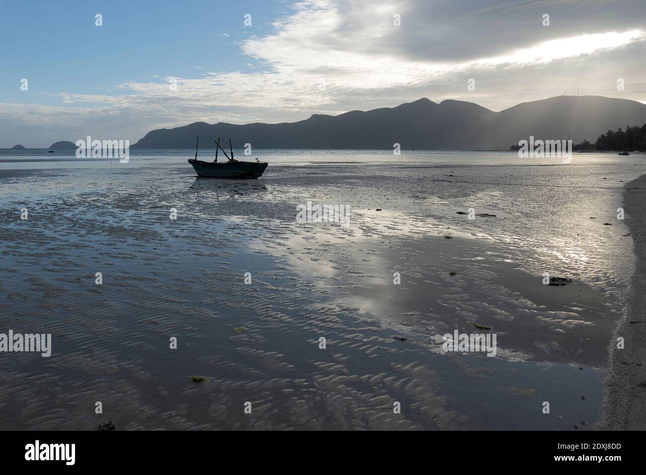 Small fishing boat on the beach at low tide in Vietnam Stock Photo