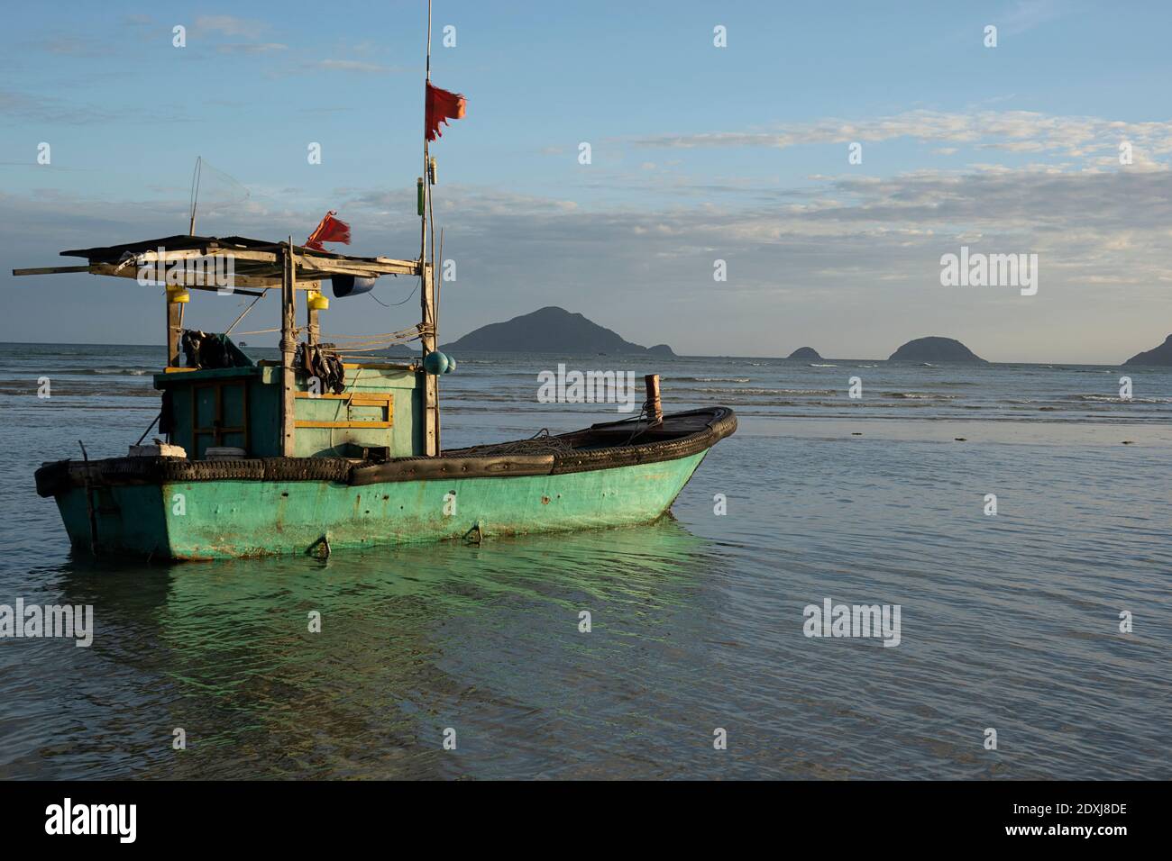 Small fishing boat on the beach at low tide in Vietnam Stock Photo