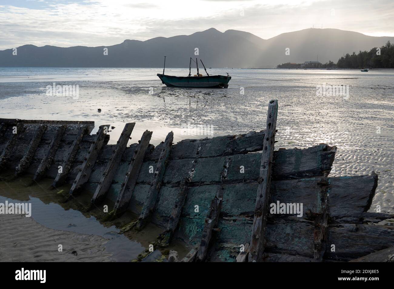 Wrecked fishing boat on the beach at low tide in Vietnam Stock Photo