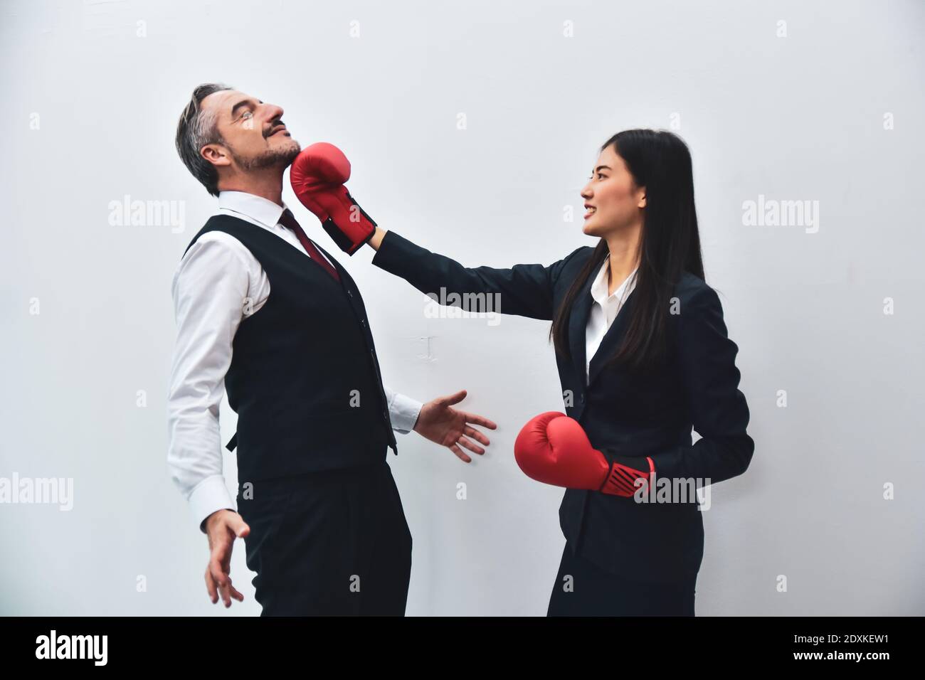 Office worker wearing boxing gloves Punch to the boss's face. Stock Photo