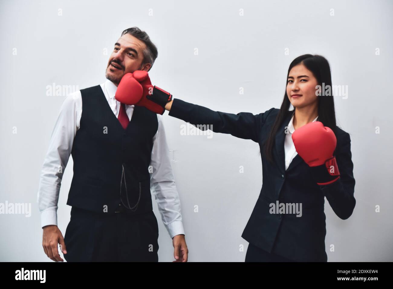 Office worker wearing boxing gloves Punch to the boss's face. Stock Photo