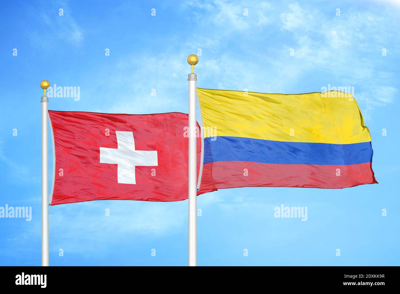 Switzerland and Colombia two flags on flagpoles and blue sky Stock Photo