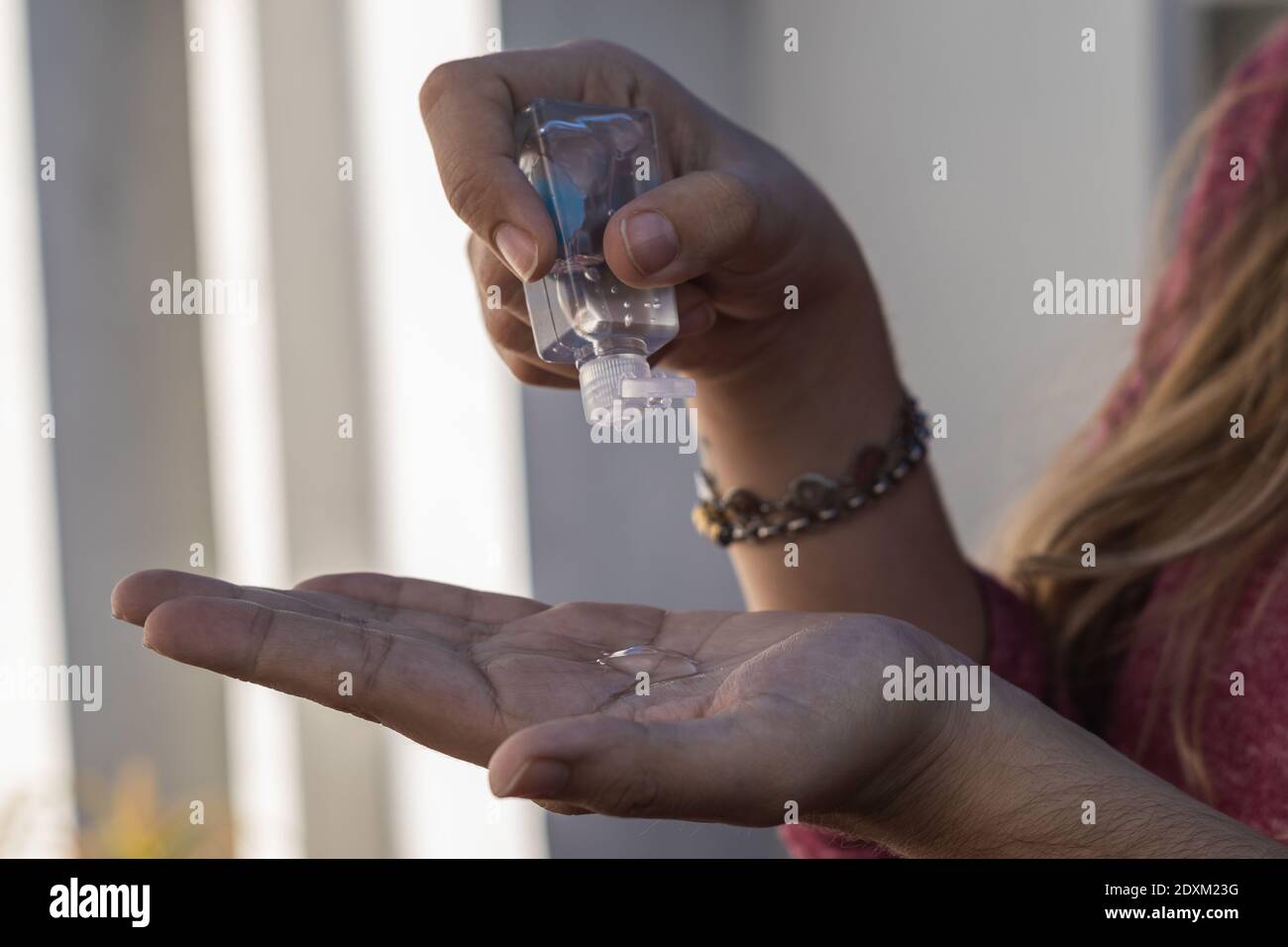 A female disinfecting her hands with gel alcohol or hand sanitizer gel ...