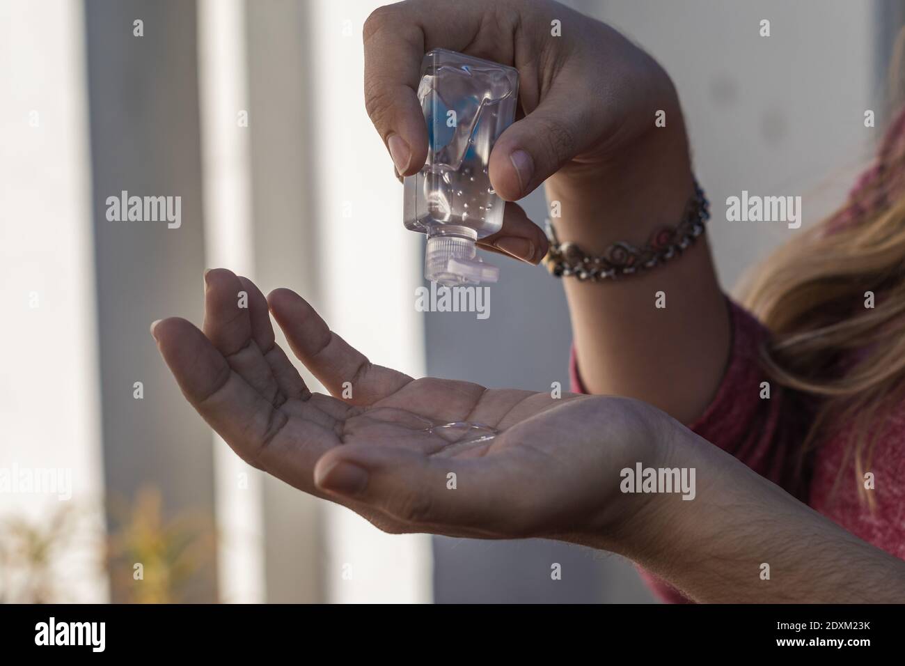 A female disinfecting her hands with gel alcohol or hand sanitizer gel ...