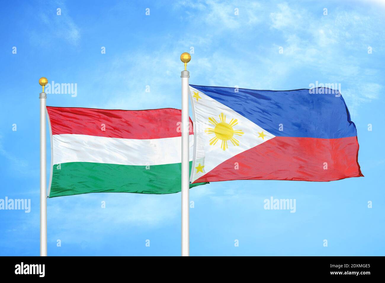 Hungary and Philippines two flags on flagpoles and blue cloudy sky ...