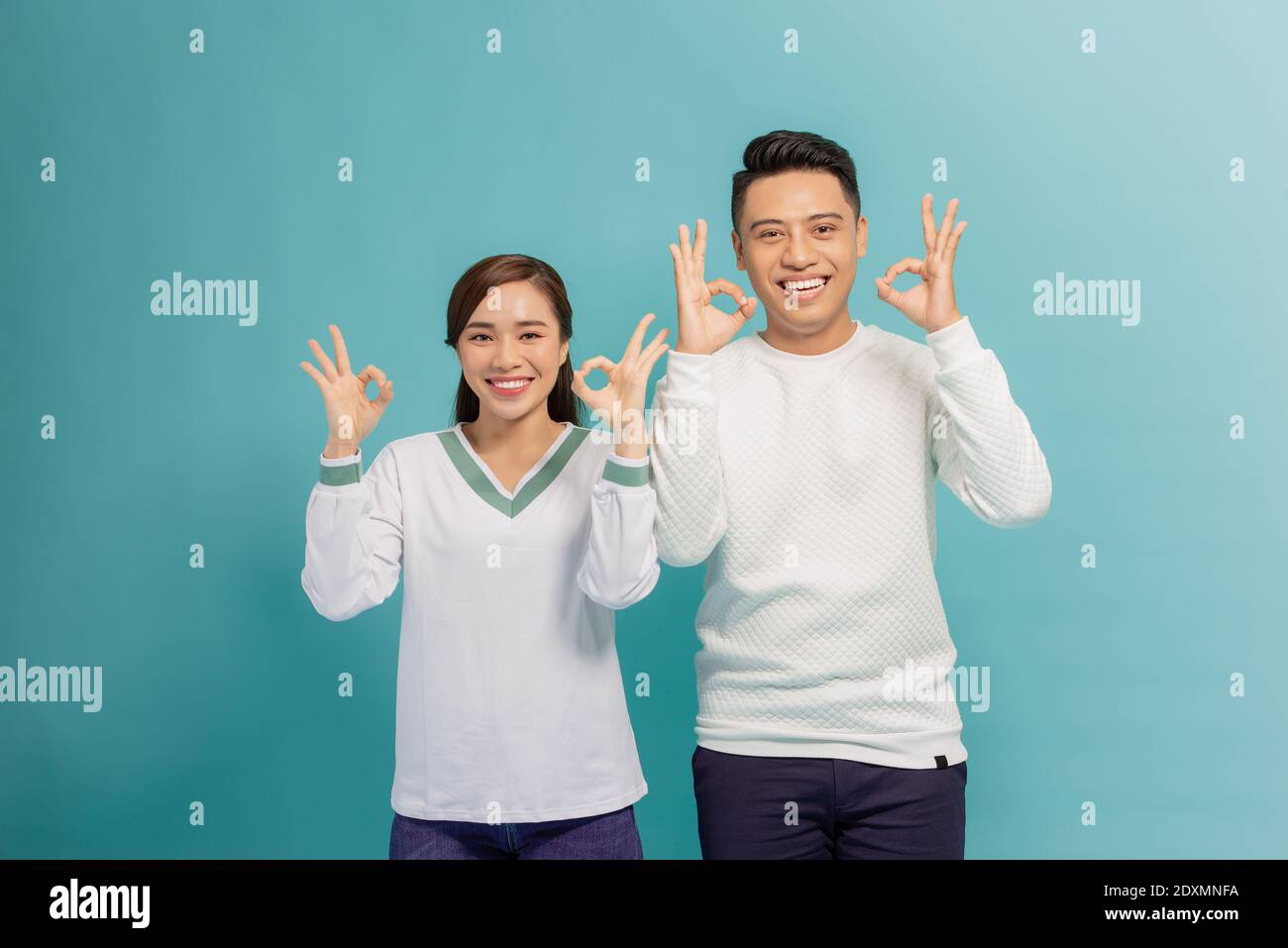 Happy Asian couple love excited smiling with ok hand gesture Stock Photo