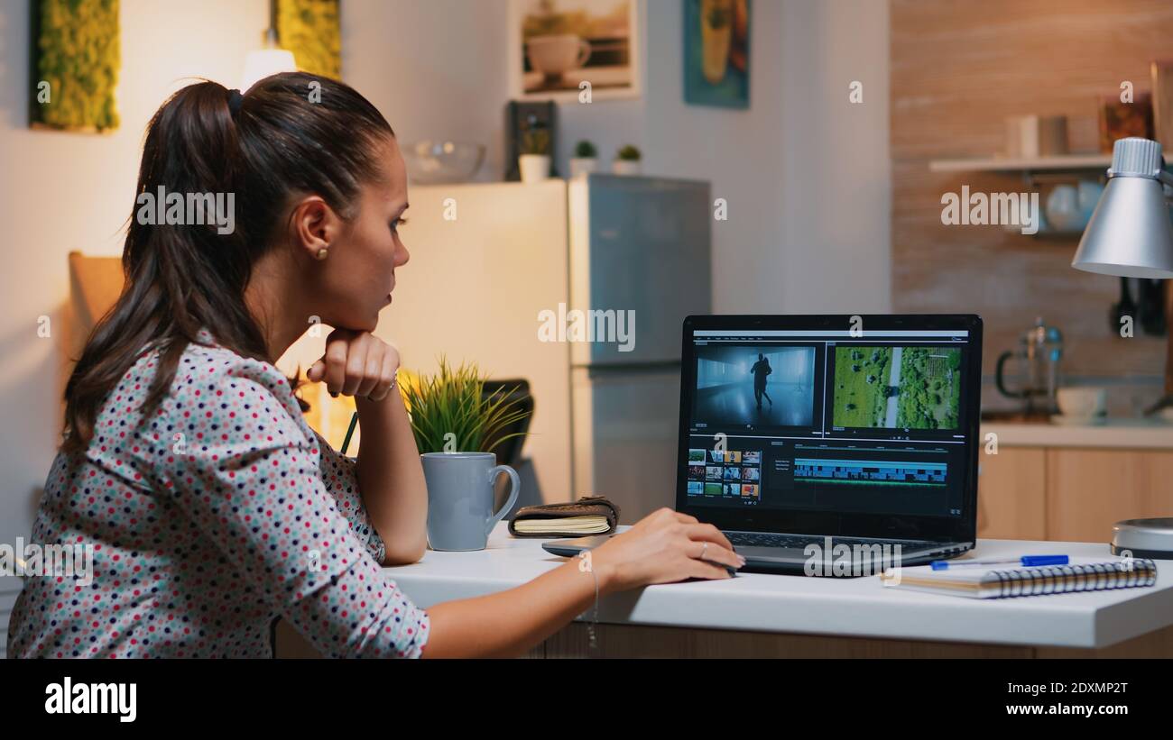 Videographer editing from home on professional laptop sitting on desk in  modern kitchen in midnight. Creative video editor working at night at new  project processing audio film montage Stock Photo - Alamy