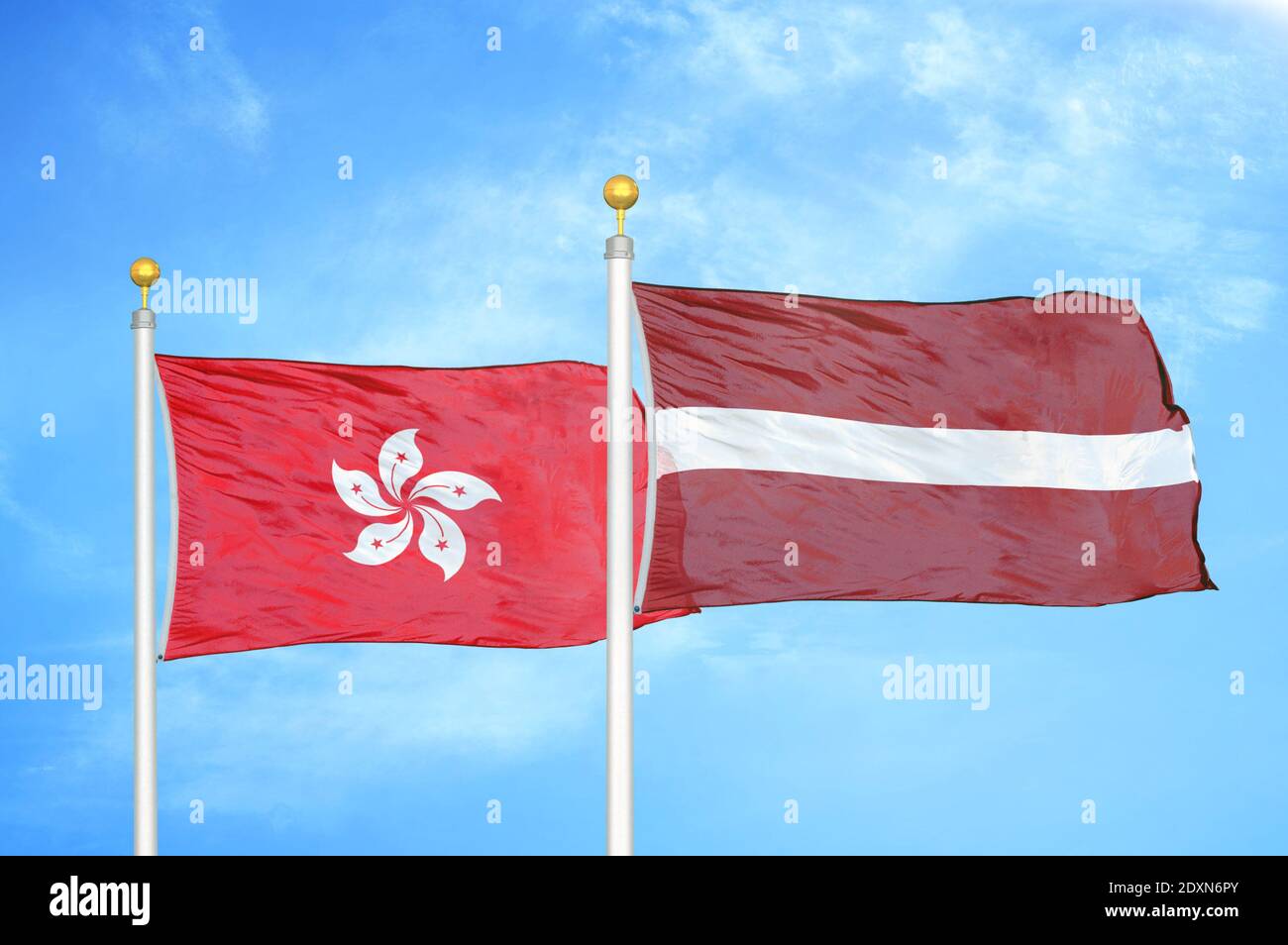 Hong Kong and Latvia two flags on flagpoles and blue cloudy sky Stock Photo