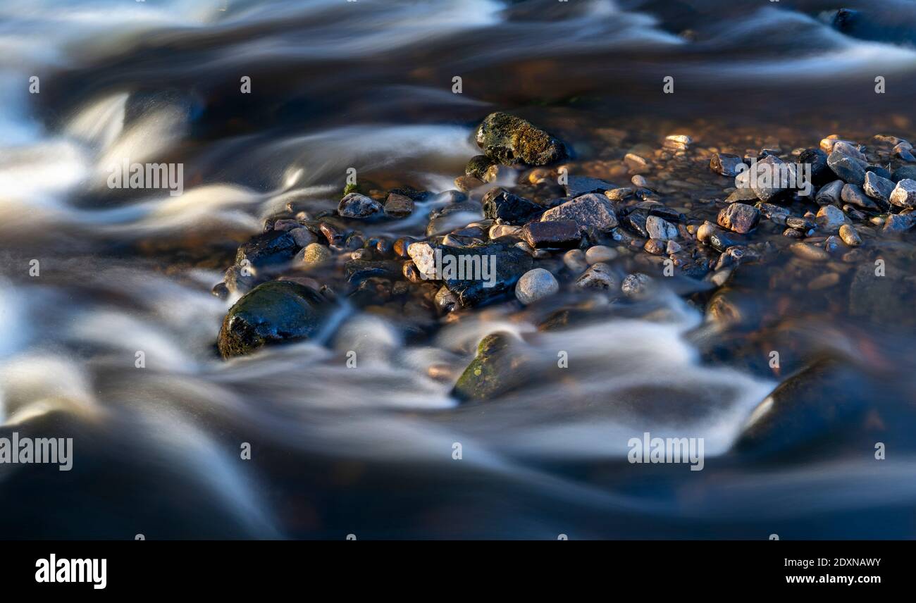 Long exposure of river flowing past rocks on Cotterdale Beck, Yorkshire Dales National Park, UK. Stock Photo