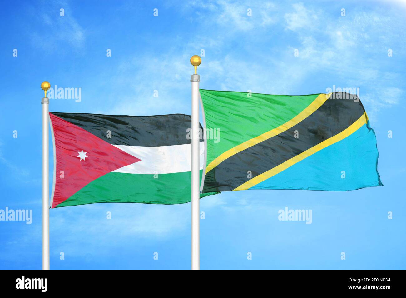 Jordan and Tanzania two flags on flagpoles and blue cloudy sky Stock Photo