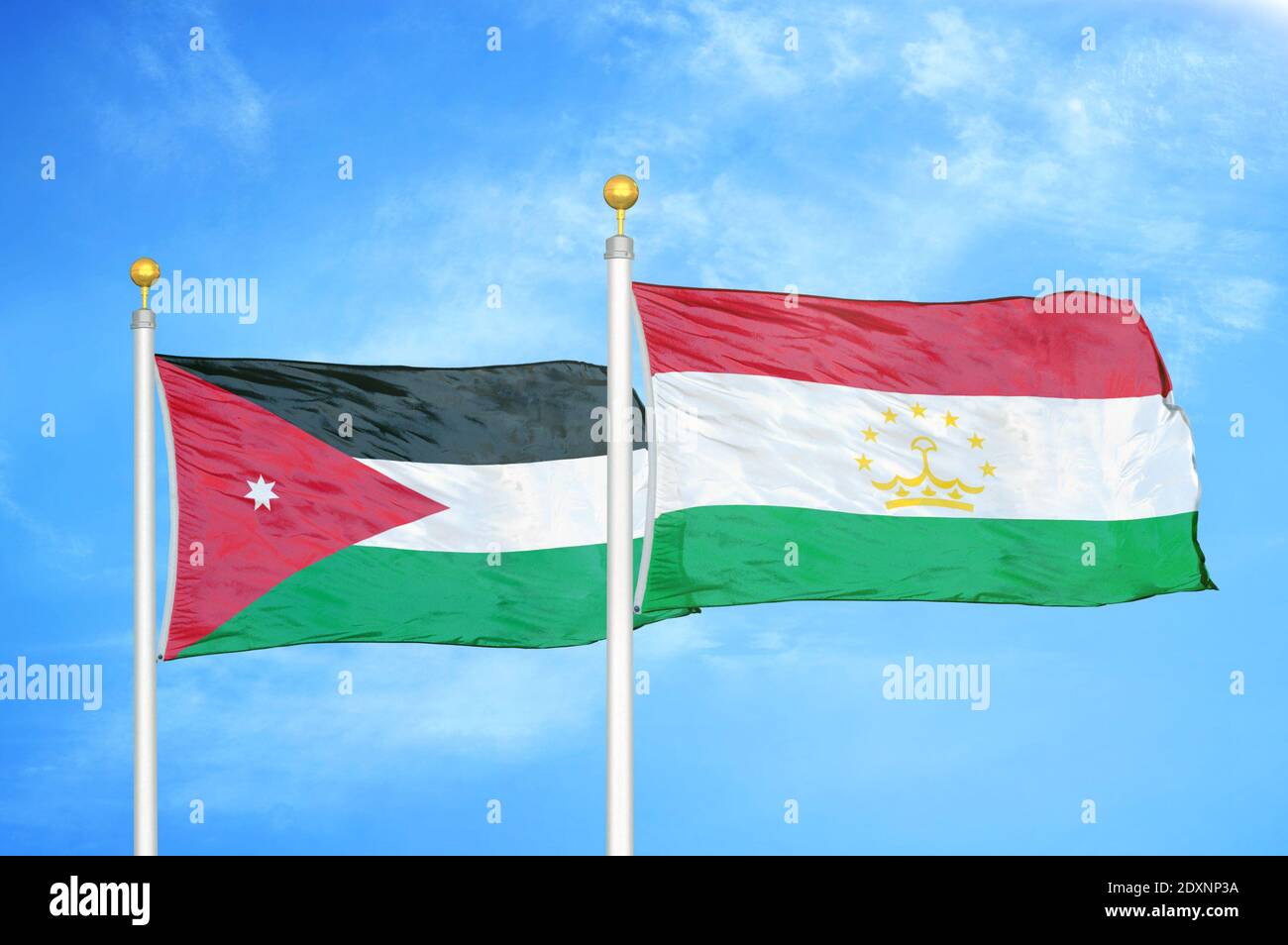 Jordan and Tajikistan two flags on flagpoles and blue cloudy sky Stock Photo