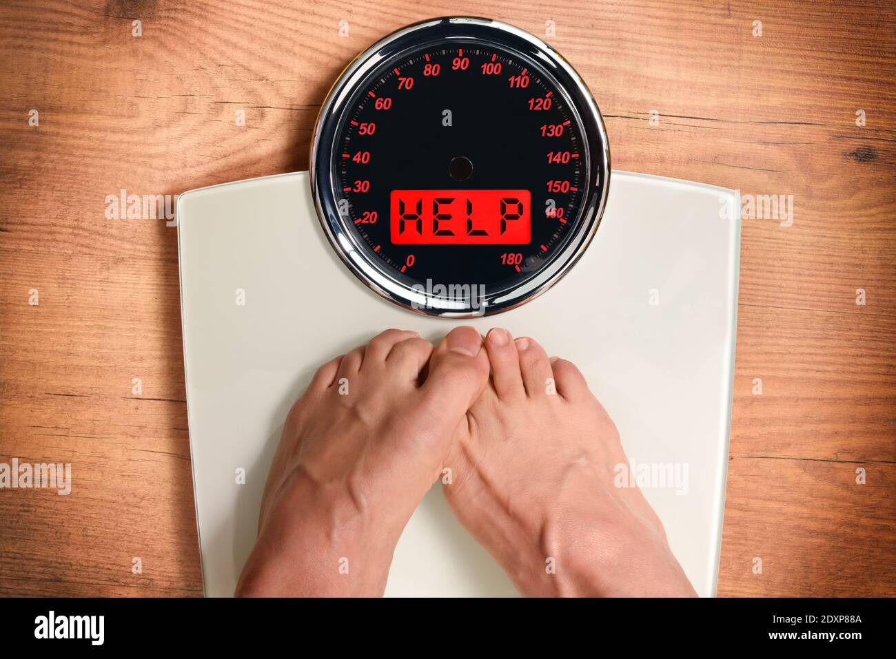 Ideal weight concept with feet being weighed on a scale and help message on wooden pallet. Top view. Horizontal composition. Stock Photo