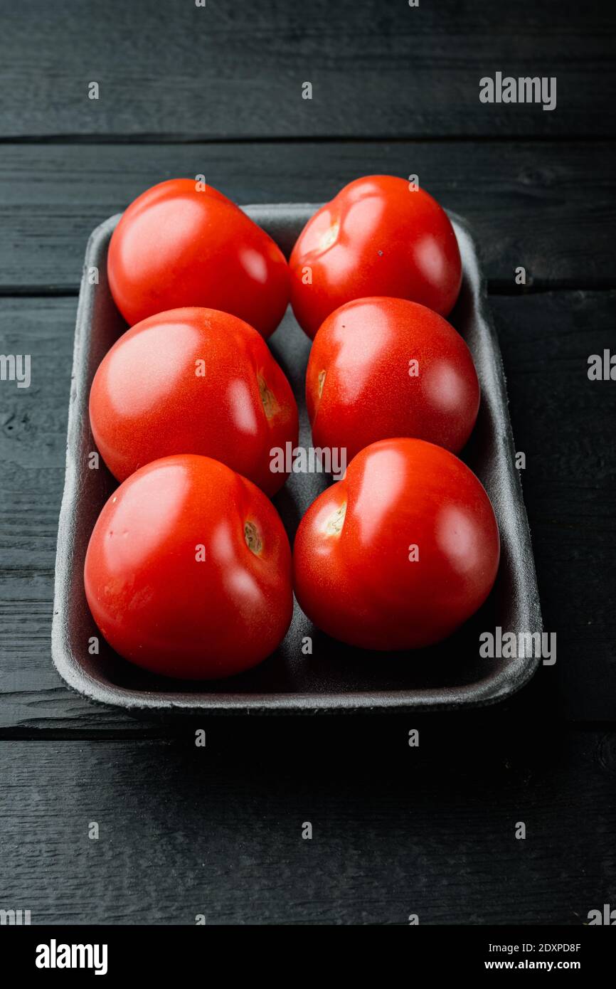 Red ripe tomatoes, on black wooden table Stock Photo - Alamy