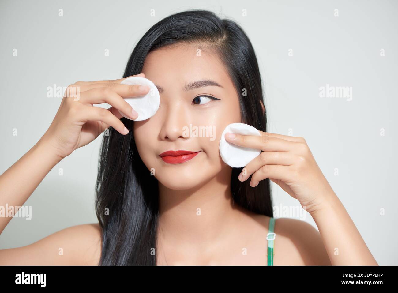 Healthy fresh asian girl removing makeup from her face with cotton pad  smiling Stock Photo - Alamy