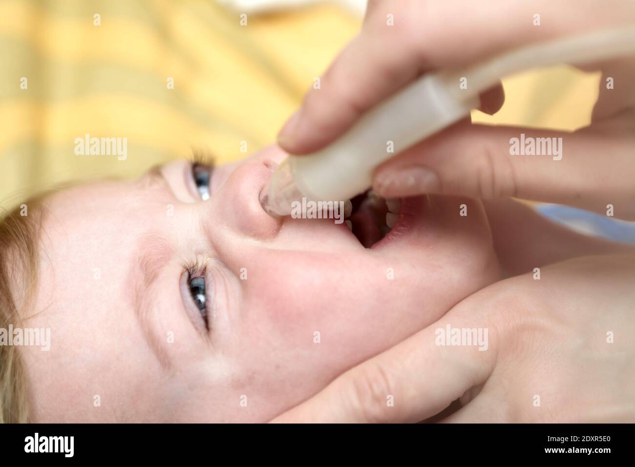 Mother using child's nasal aspirator for her son Stock Photo