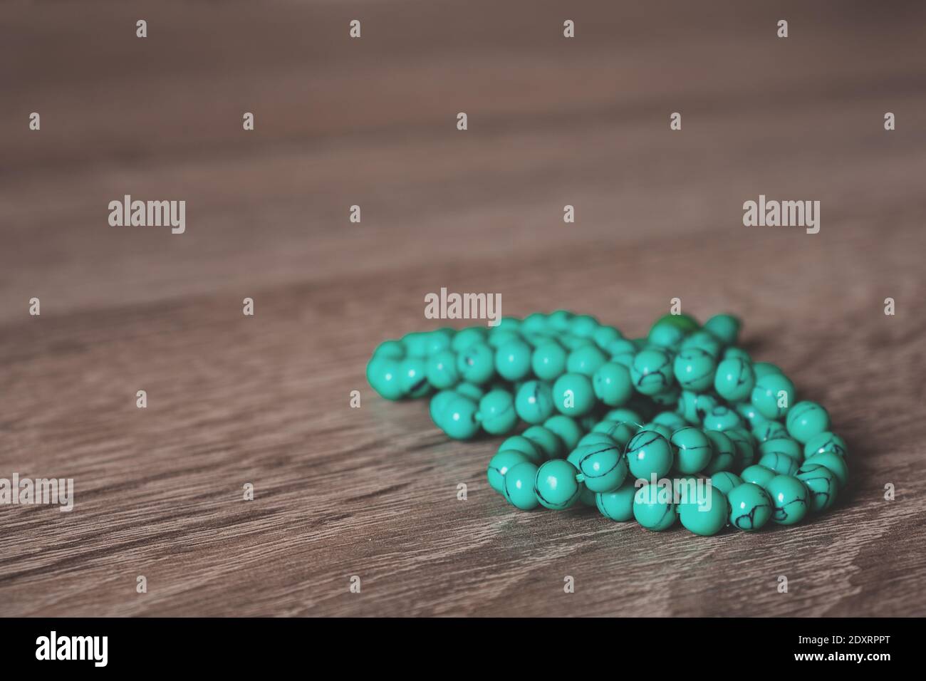 Close-up of a turquoise Buddhist Prayer Beads (called Mala) on a wooden background Stock Photo