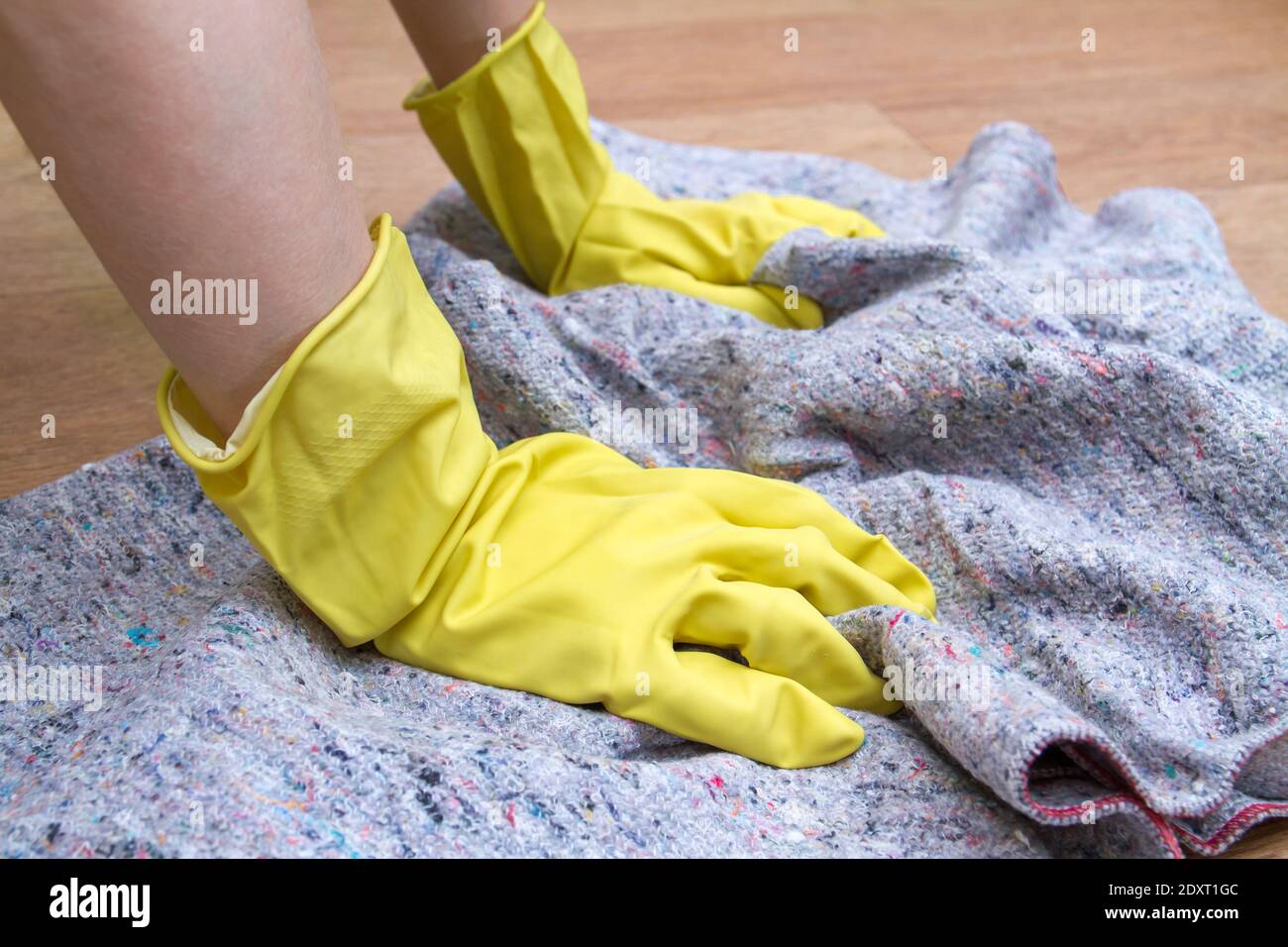Girl in rubber gloves washes the floor at home with a rag. Concept of ...
