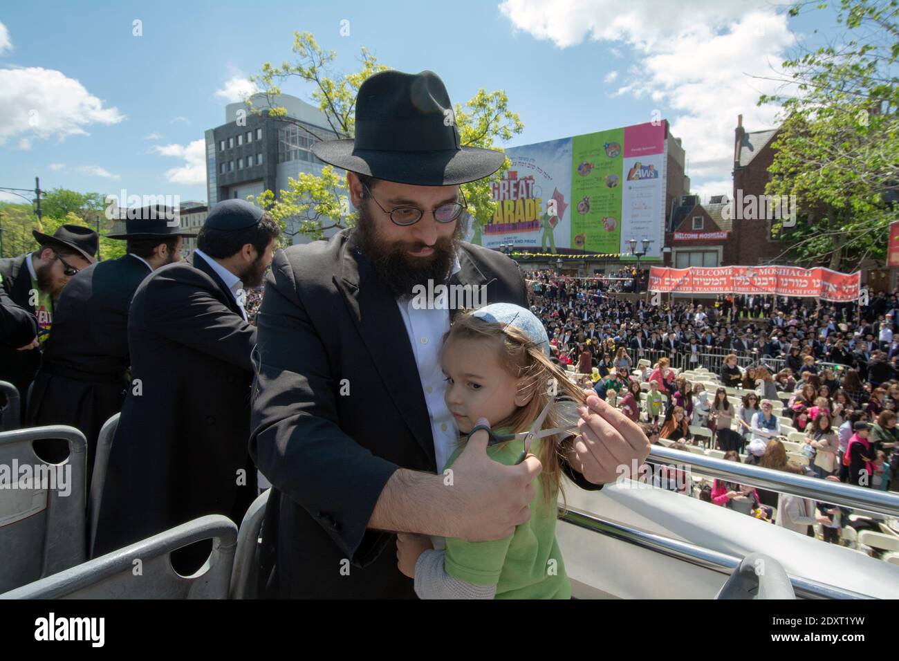 A 3 year old Jewish boy gets his first haircut at the Lubavitch Great Parade on Lag B'Omer. In Crown Heights, Brooklyn, New York. Stock Photo