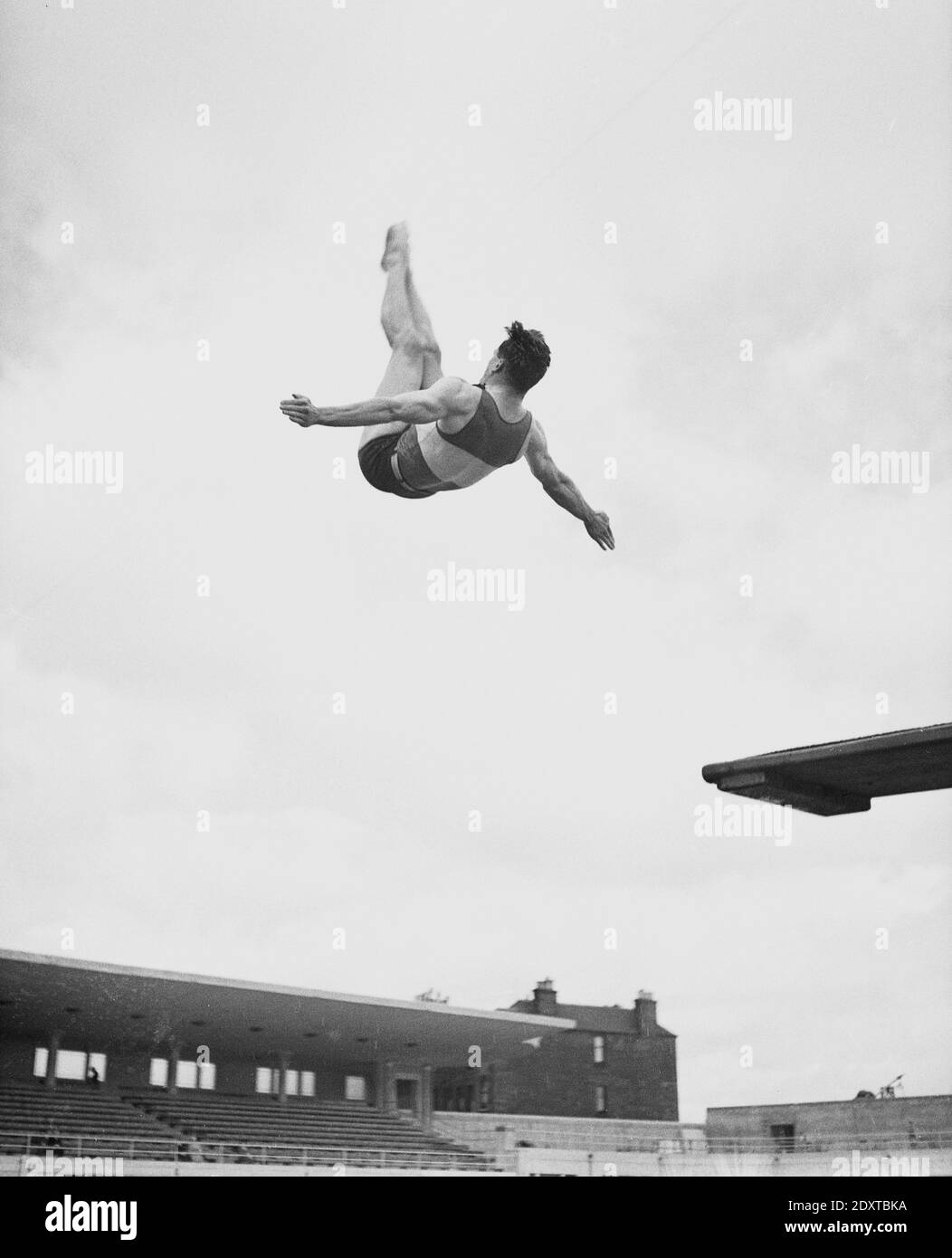1950s, historical, a male diver, legs together, arms apart in a somersault at the open air Lido, Gravesend, Kent, England, UK. Opened in 1938, it closed in 1989. Stock Photo