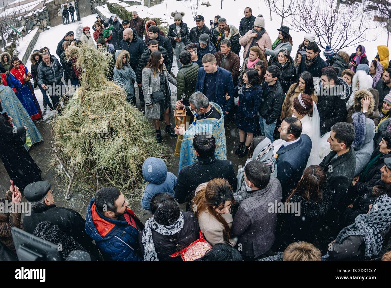Ashtarak, Armenia, Saint Marianeh church, January 14, 2020 - The priest doing ritual of Trndez and people waiting for the burning ceremony Stock Photo