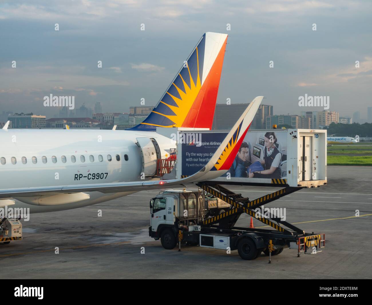 Philippine Airlines Airbus A321 receiving supplies from a catering truck early in the morning at Terminal 2 of Ninoy Aquino International Airport in M Stock Photo