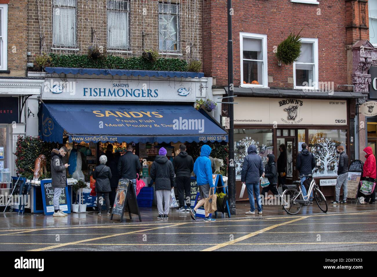 Queues of shoppers lining up to collect their Christmas supplies outside a local fishmongers in Twickenham, Richmond, England, UK Stock Photo
