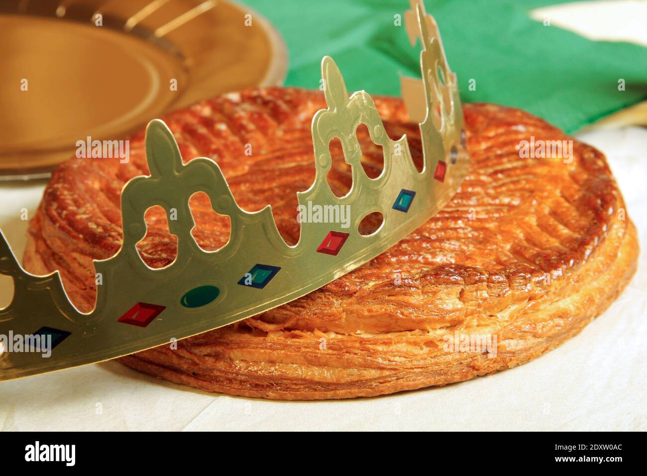 French tradition of galette des rois. Kings epiphany cake with a golden crown lying on a table - Stock Image