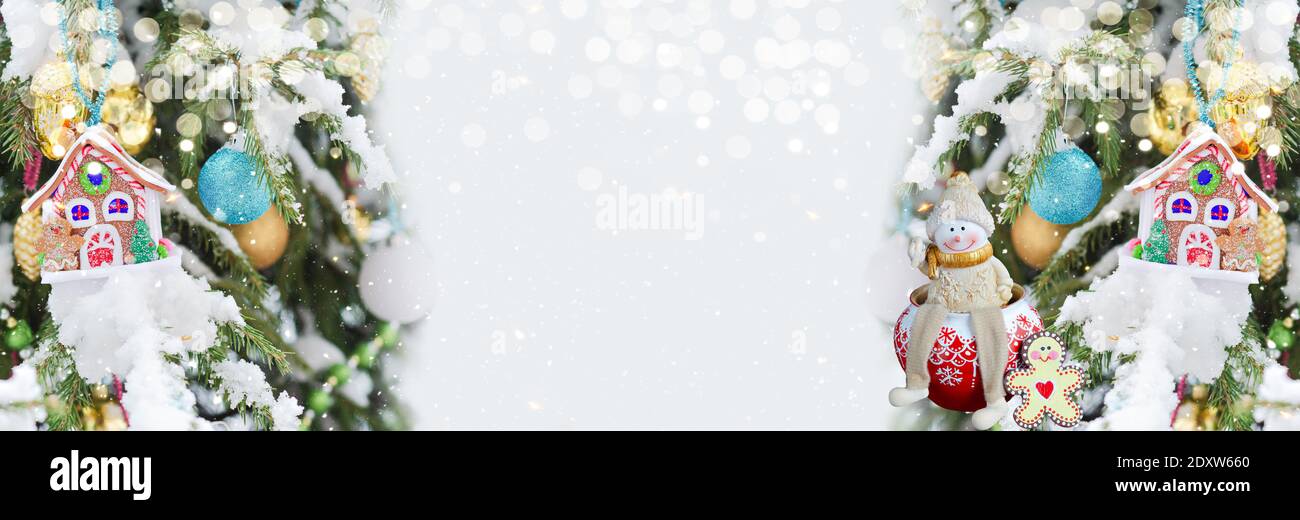 Christmas defocused widescreen background with decorated Christmas trees and a toy snowman. New Year's winter art design, banner Stock Photo