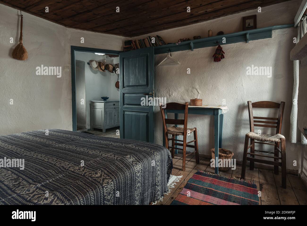 Traditional interior of old bedroom with handmade wooden furniture and traditional  folk ornament textile in historic country village house Stock Photo