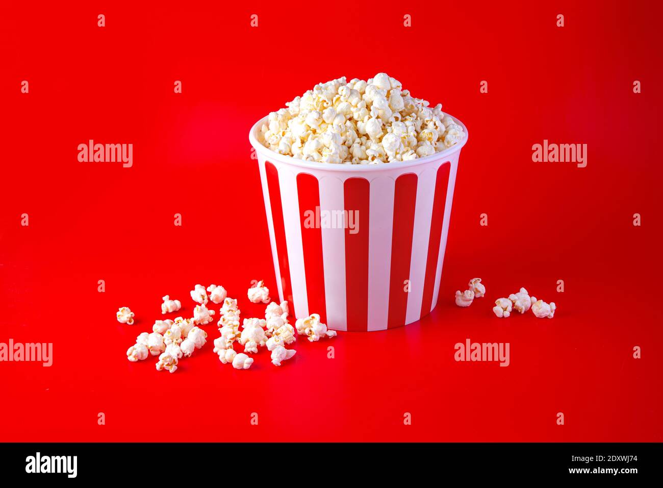 Striped box with popcorn on red background Stock Photo