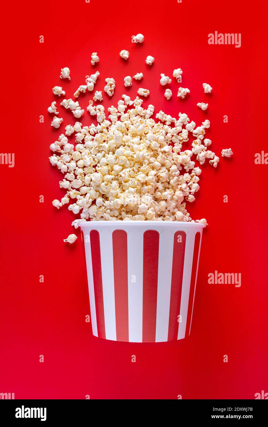 Striped box with popcorn on red background Stock Photo