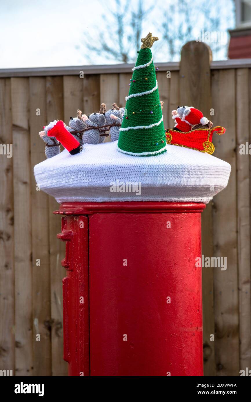 Tunbridge Wells, UK, 24 December 2020. A secret Yarn bomber has added a Christmas decoration to the post box in a tier 4 area to cheer the spirits at Christmas in Lockdown. A crochet Santa in his sleigh is pulled by reindeer through the snow in a festive scene.  © Sarah Mott / Alamy Live News Stock Photo