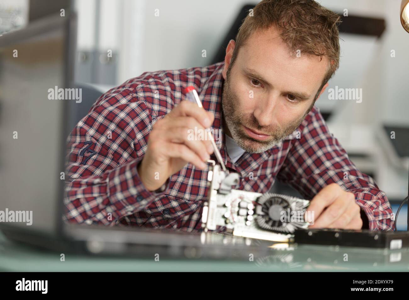 man is repairing broken pc with a screw driver Stock Photo