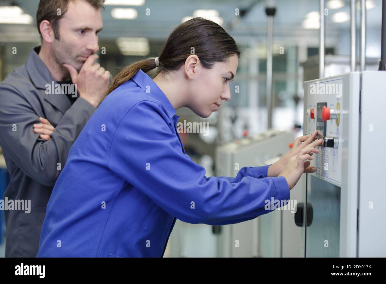 female apprentice working with engineer on cnc machinery Stock Photo