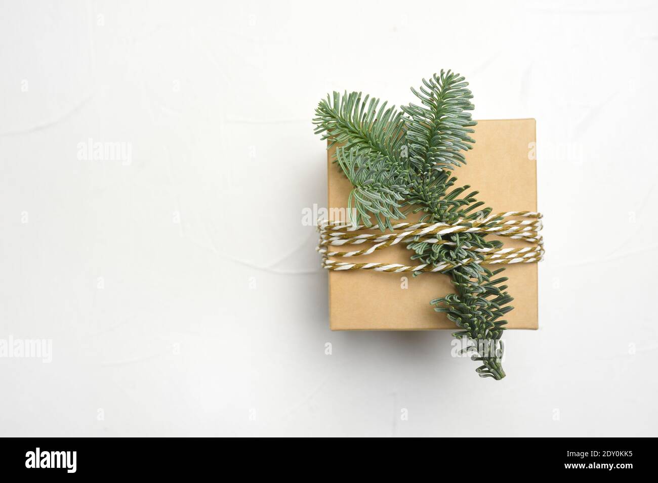 Christmas composition with green fir branches and kraft gift box on ...