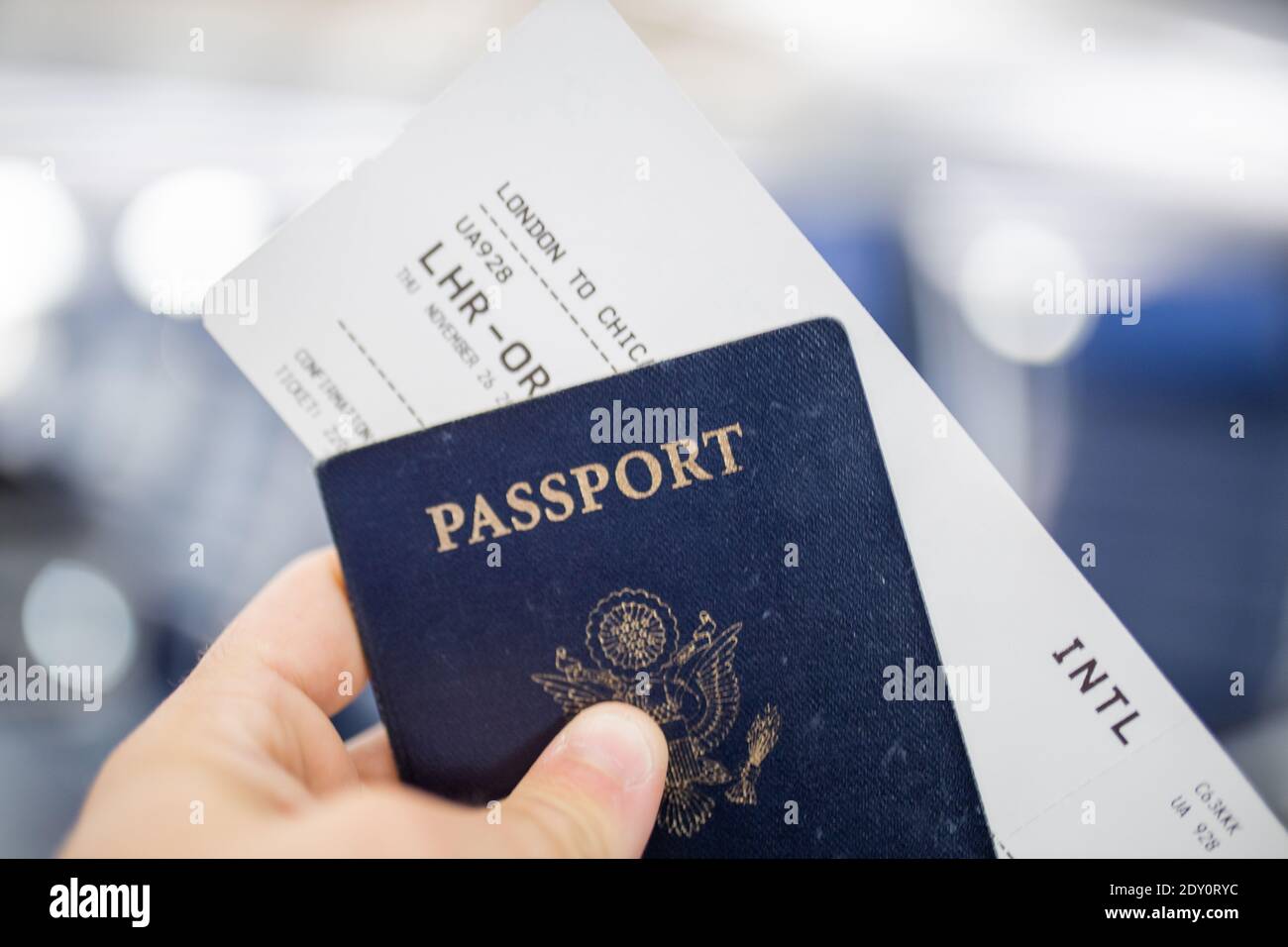 Male hand holding American passport and airplane ticket Stock Photo Alamy