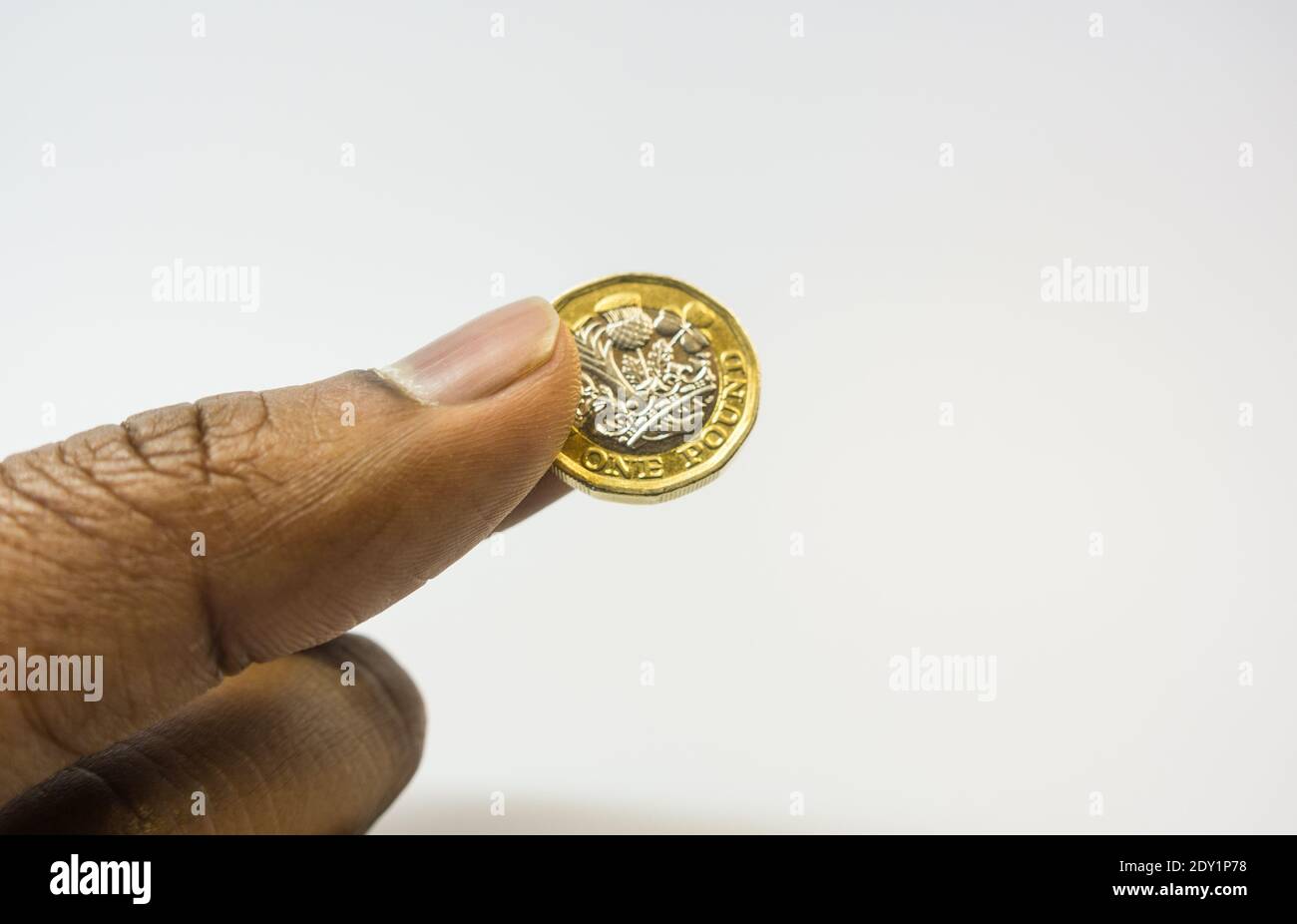 Asian man giving one pound coin on  white background Stock Photo