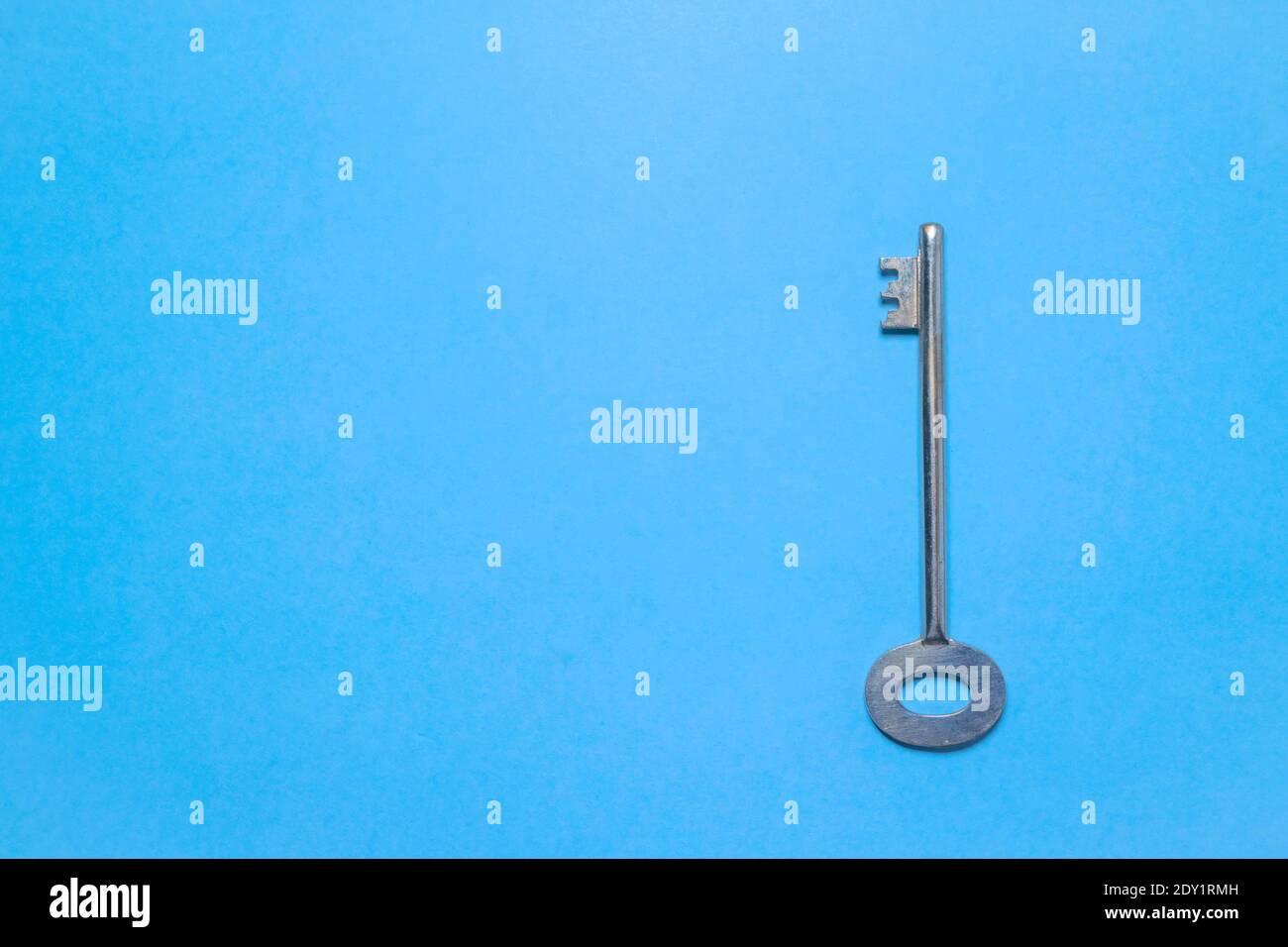 Key on blue colored background placed at the right side. Stock Photo
