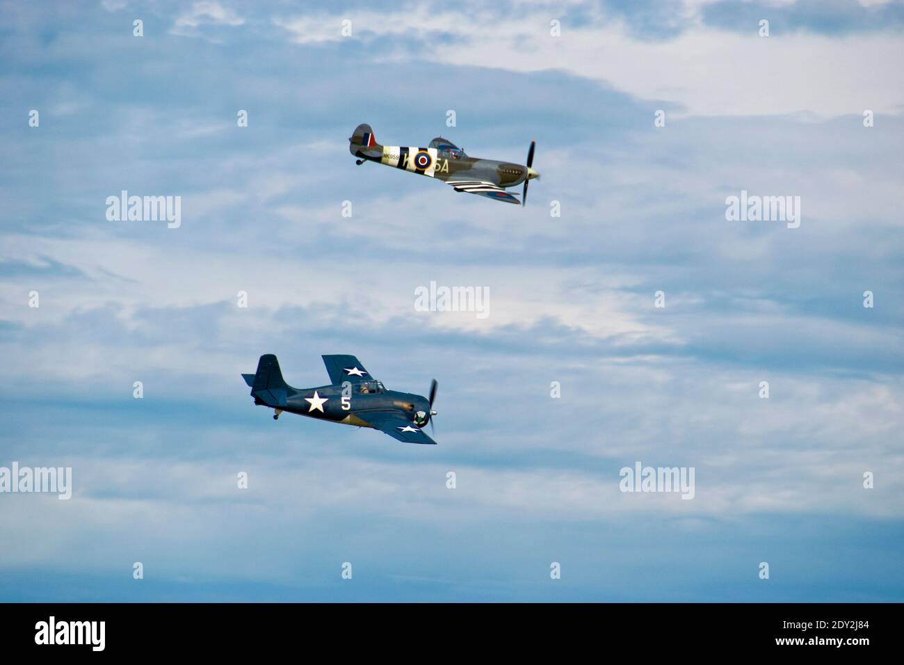 A Supermarine Spitfire and a Grumman Wildcat, World War Two fighter planes, fly over the Oshkosh, Wisconsin airport. Photographed from public property Stock Photo