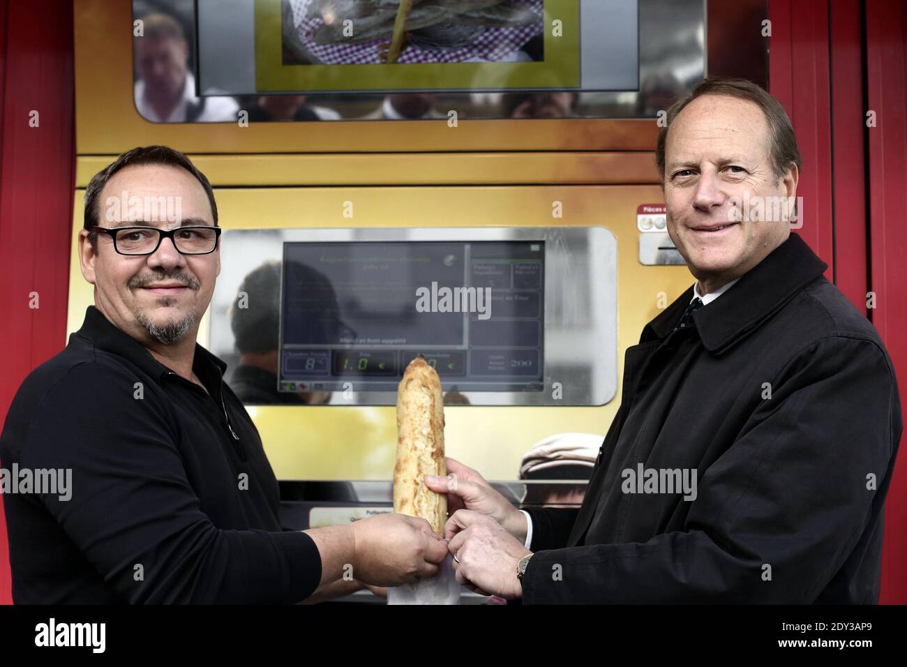 French baker Jean-Louis Hecht (L) poses with Philippe Goujon, the mayor of  the 15th arrondissement, in front of his baguette dispenser, the  PaniVending, during its inauguration outside 'La Panamette' bakery in Paris,