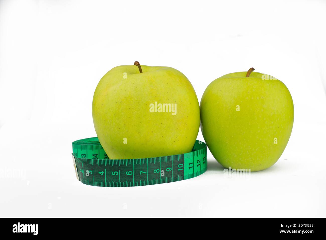 green apples with measuring centimeter for weight control and health and diet on a white background Stock Photo