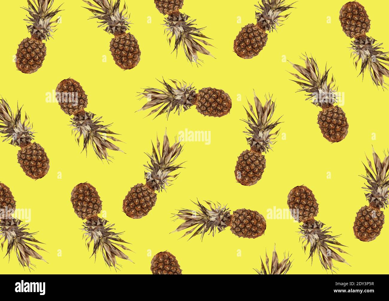 tropical pattern with exotic pineapple fruit on a yellow background Stock Photo